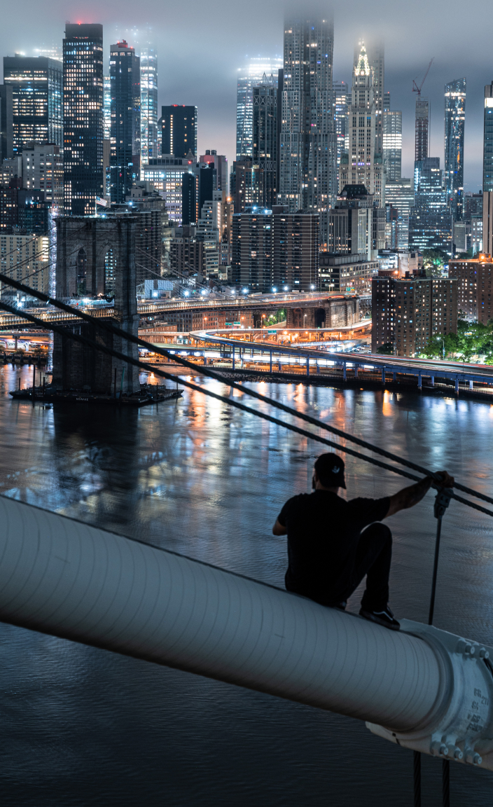 Drifter Shoots aka Isaac Wright sitting on cable of bridge overlooking New York City